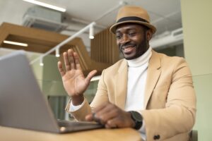 Well-dressed male digital nomad teleconferencing from cafe.