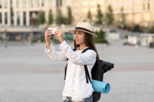 Female traveler take photo of scenery with her smartphone.